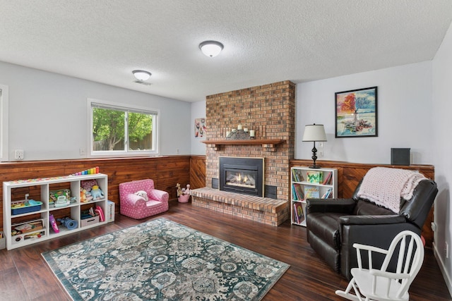 265 107th Ln NW, Coon Rapids, MN 55448 - living area with wainscoting, wood finished floors, wooden walls, a textured ceiling, and a brick fireplace