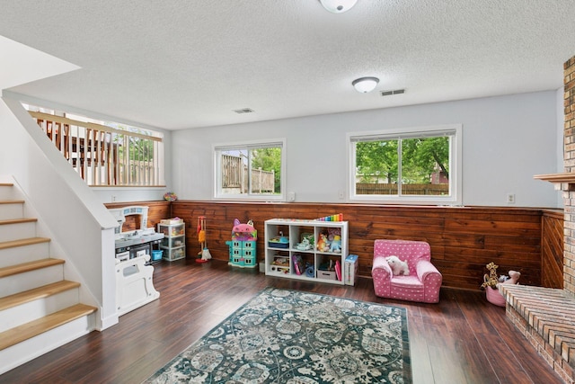 265 107th Ln NW, Coon Rapids, MN 55448 - living area with hardwood / wood-style floors, a textured ceiling, stairs, a wainscoted wall, and wood walls