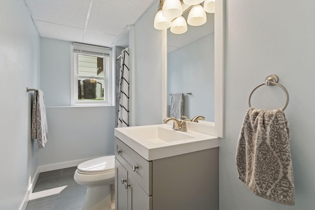 265 107th Ln NW, Coon Rapids, MN 55448 - bathroom featuring vanity, a paneled ceiling, baseboards, toilet, and tile patterned flooring