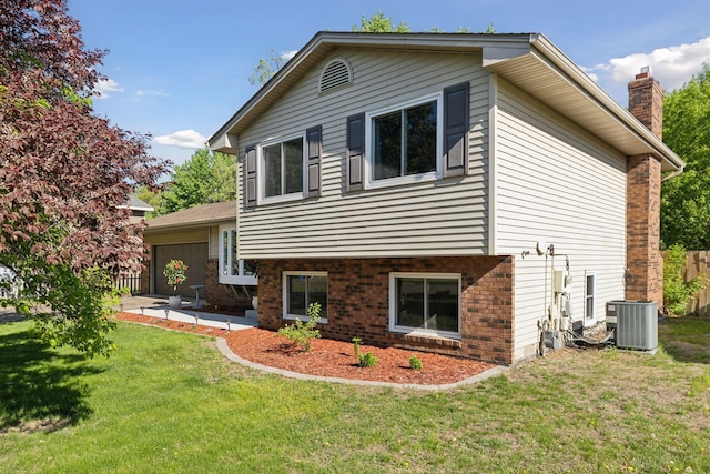 265 107th Ln NW, Coon Rapids, MN 55448 - back of property featuring brick siding, central AC unit, a yard, and an attached garage