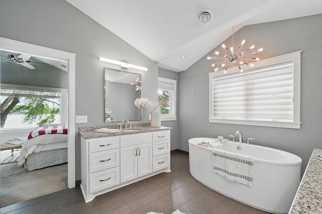 5035 Wren Rd, Mound, MN 55364 - ensuite bathroom featuring lofted ceiling, vanity, a freestanding tub, a chandelier, and baseboards