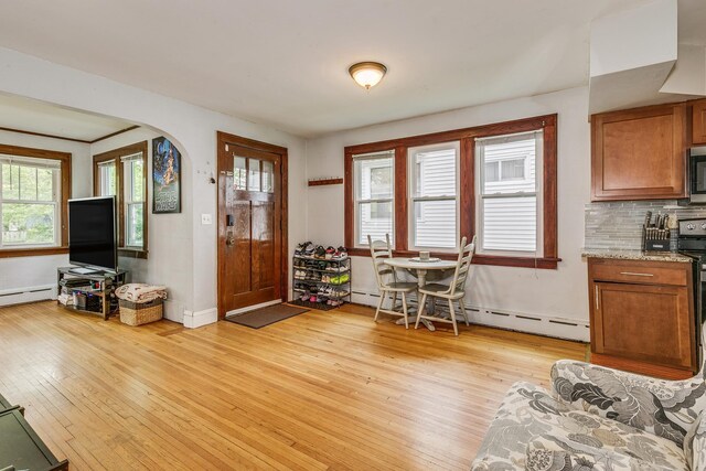 1167 Geranium Ave E, Saint Paul, MN 55106 - foyer featuring light wood-style flooring, arched walkways, baseboard heating, and baseboards