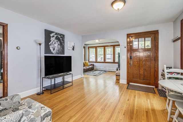1167 Geranium Ave E, Saint Paul, MN 55106 - foyer with arched walkways, light wood finished floors, a baseboard radiator, and baseboards