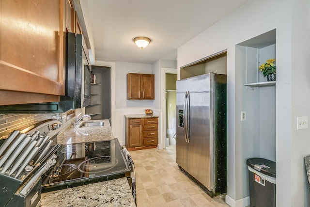 1167 Geranium Ave E, Saint Paul, MN 55106 - kitchen with stainless steel fridge, brown cabinets, electric stove, light stone countertops, and a sink