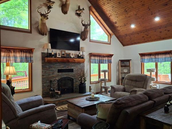 29805 Arbo Rd, Grand Rapids, MN 55744 - living area with high vaulted ceiling, wooden ceiling, a stone fireplace, and healthy amount of natural light