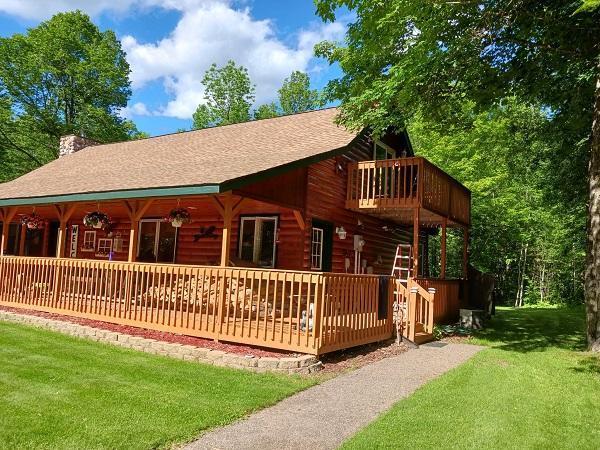 29805 Arbo Rd, Grand Rapids, MN 55744 - back of house featuring a lawn, a chimney, a shingled roof, a wooden deck, and a balcony