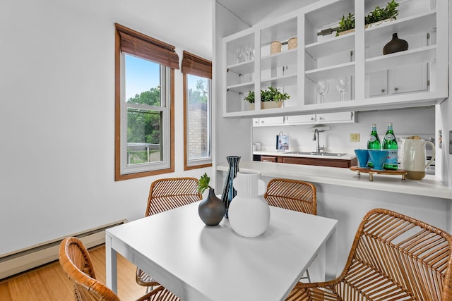 1405 40th St Unit 15F, Minneapolis, MN 55407 - dining room featuring a baseboard heating unit and light wood-style floors