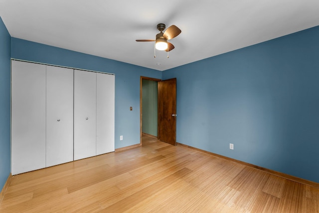 1405 40th St Unit 15F, Minneapolis, MN 55407 - unfurnished bedroom featuring wood finished floors, a closet, baseboards, and a ceiling fan