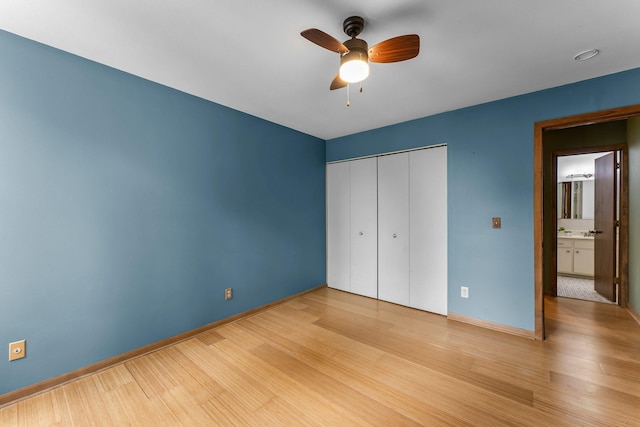 1405 40th St Unit 15F, Minneapolis, MN 55407 - unfurnished bedroom with baseboards, a closet, wood finished floors, and ceiling fan