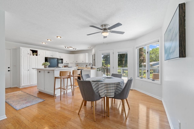 6540 Zealand Ave N, Brooklyn Park, MN 55428 - dining area with a textured ceiling, a ceiling fan, and light wood-style flooring