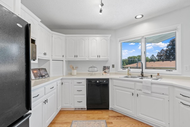 6540 Zealand Ave N, Brooklyn Park, MN 55428 - kitchen with black appliances, light wood-type flooring, a textured ceiling, white cabinets, and light countertops