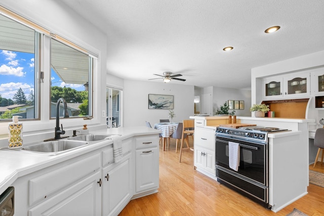 6540 Zealand Ave N, Brooklyn Park, MN 55428 - kitchen featuring black electric range, light wood-type flooring, white cabinetry, a ceiling fan, and light countertops