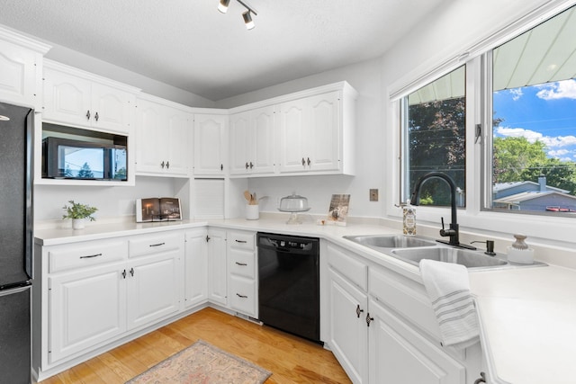 6540 Zealand Ave N, Brooklyn Park, MN 55428 - kitchen with black dishwasher, freestanding refrigerator, light wood finished floors, white cabinets, and light countertops