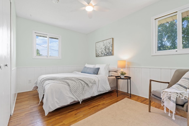 6540 Zealand Ave N, Brooklyn Park, MN 55428 - bedroom with a wainscoted wall, wood finished floors, and ceiling fan