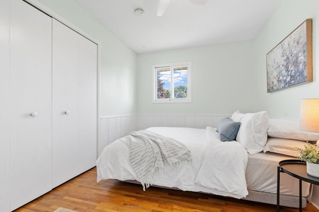 6540 Zealand Ave N, Brooklyn Park, MN 55428 - bedroom featuring a wainscoted wall, wood finished floors, a closet, and ceiling fan