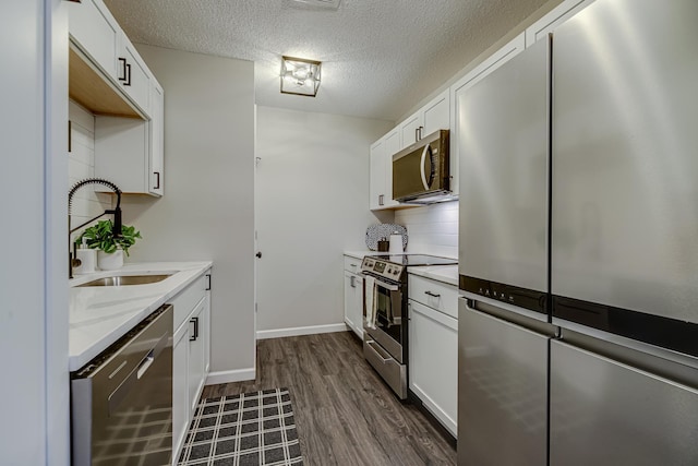 1034 Carmel Ct, Shoreview, MN 55126 - kitchen with stainless steel appliances, a sink, dark wood finished floors, a textured ceiling, and white cabinets
