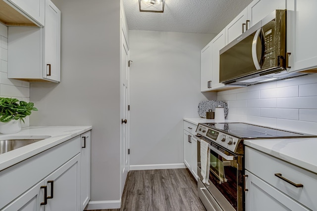 1034 Carmel Ct, Shoreview, MN 55126 - kitchen with appliances with stainless steel finishes, decorative backsplash, dark wood-style flooring, a textured ceiling, and white cabinets
