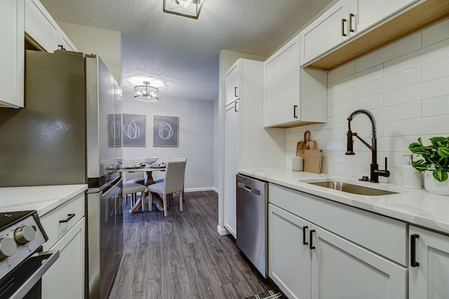 1034 Carmel Ct, Shoreview, MN 55126 - kitchen with appliances with stainless steel finishes, a sink, backsplash, a textured ceiling, and white cabinets