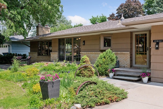 10933 Chowen Ave S, Bloomington, MN 55431 - view of front of house with a chimney, brick siding, and a shingled roof