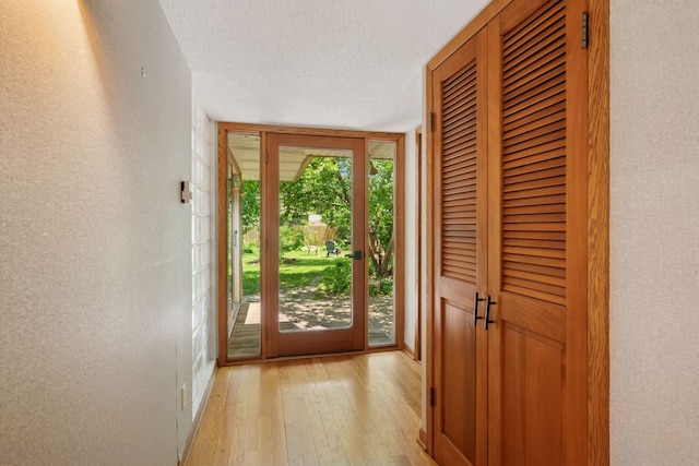 10933 Chowen Ave S, Bloomington, MN 55431 - doorway with light wood-style floors, a textured ceiling, and a textured wall