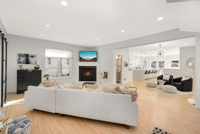 150 1st St, Excelsior, MN 55331 - living area with a glass covered fireplace, healthy amount of natural light, light wood-style flooring, a chandelier, and recessed lighting