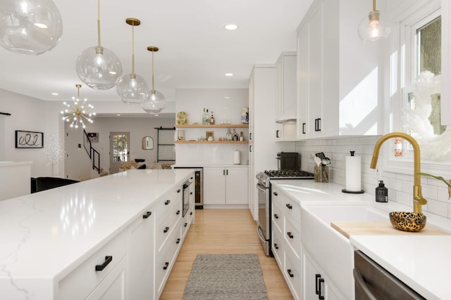 150 1st St, Excelsior, MN 55331 - kitchen with appliances with stainless steel finishes, tasteful backsplash, recessed lighting, white cabinetry, and light wood-style floors