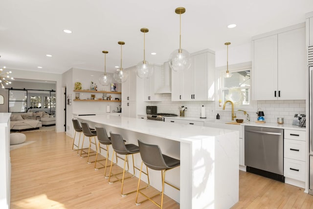 150 1st St, Excelsior, MN 55331 - kitchen with stainless steel appliances, a sink, decorative backsplash, light wood finished floors, and recessed lighting