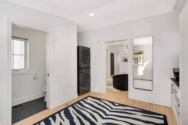 150 1st St, Excelsior, MN 55331 - laundry room featuring stacked washer and clothes dryer, light wood-style floors, baseboards, and recessed lighting