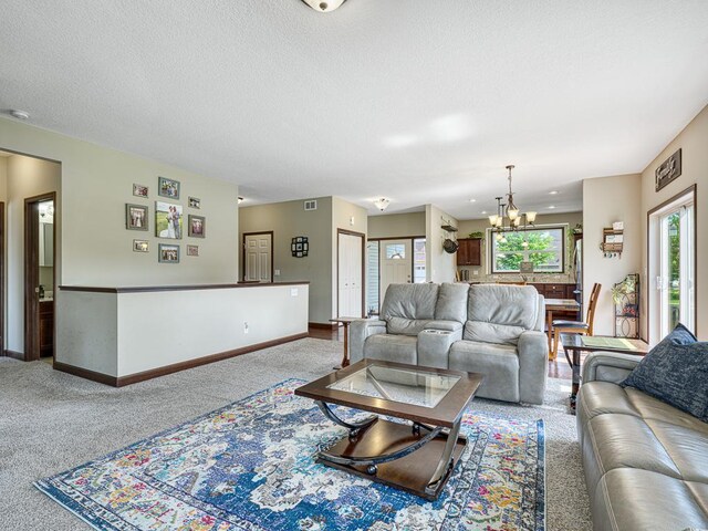 6024 158th St W, Apple Valley, MN 55124 - living area featuring carpet flooring, a chandelier, baseboards, and a textured ceiling