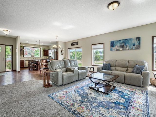 6024 158th St W, Apple Valley, MN 55124 - living room featuring dark colored carpet, a chandelier, a textured ceiling, and baseboards