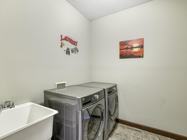 6024 158th St W, Apple Valley, MN 55124 - laundry area featuring washer and clothes dryer, baseboards, and a textured ceiling