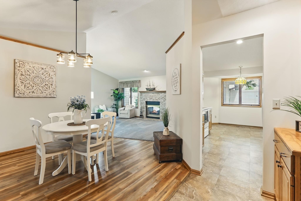 70 Jackson Ct, Hastings, MN 55033 - dining area with plenty of natural light, vaulted ceiling, a brick fireplace, and baseboards