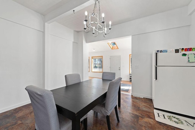 408 State St E, Grey Eagle, MN 56336 - dining room featuring stone tile flooring, a chandelier, and baseboards