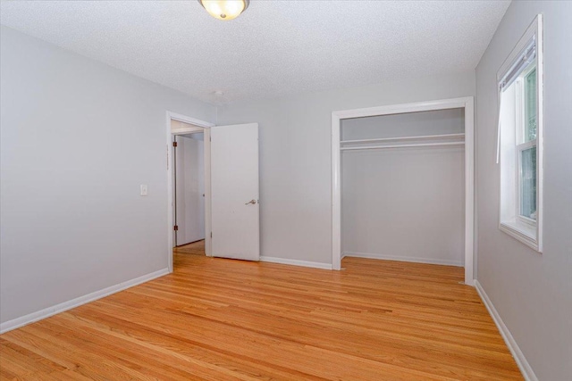 1637 37th Ave NE, Columbia Heights, MN 55421 - unfurnished bedroom featuring light wood-style flooring, a textured ceiling, a closet, and baseboards