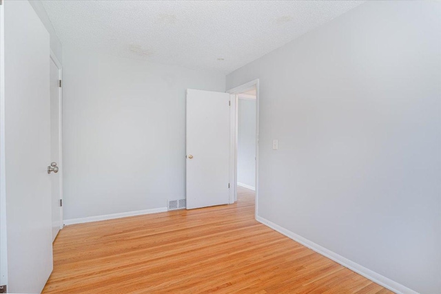1637 37th Ave NE, Columbia Heights, MN 55421 - unfurnished room with light wood-type flooring, baseboards, and a textured ceiling