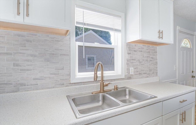1637 37th Ave NE, Columbia Heights, MN 55421 - kitchen with a sink, white cabinetry, decorative backsplash, and light countertops