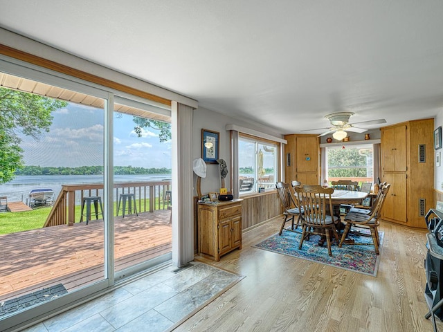 46427 Cambridge Dr, Stanchfield, MN 55080 - dining room featuring a ceiling fan, light wood-style floors, and a water view