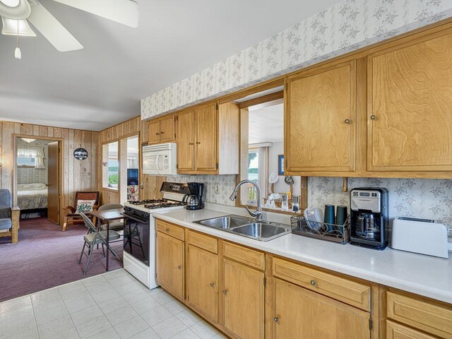46427 Cambridge Dr, Stanchfield, MN 55080 - kitchen featuring white appliances, wallpapered walls, a sink, light countertops, and a ceiling fan