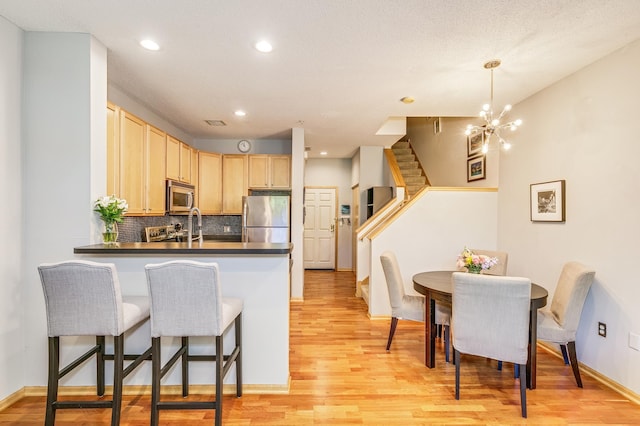 560 2nd St Unit 114, Minneapolis, MN 55401 - kitchen featuring appliances with stainless steel finishes, light wood-type flooring, recessed lighting, light brown cabinetry, and backsplash