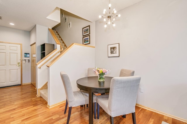 560 2nd St Unit 114, Minneapolis, MN 55401 - dining space with stairs, wood finished floors, a chandelier, and baseboards