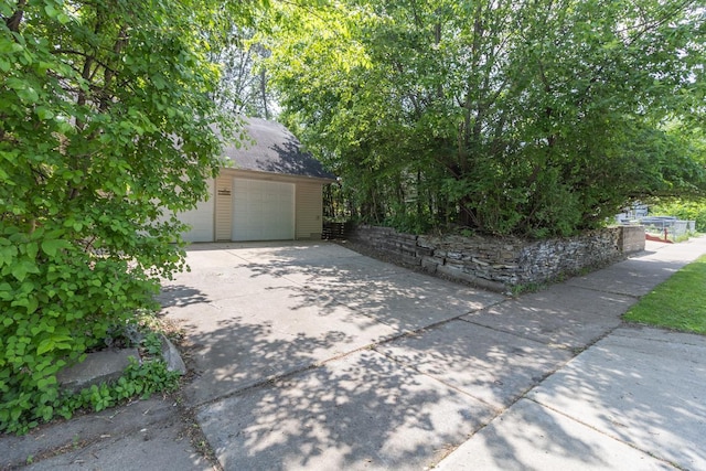 1700 Case Ave E, Saint Paul, MN 55106 - view of side of home with a garage, an outdoor structure, concrete driveway, and roof with shingles