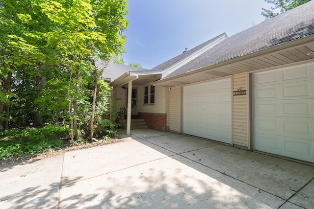 1700 Case Ave E, Saint Paul, MN 55106 - view of property exterior featuring roof with shingles, brick siding, and driveway