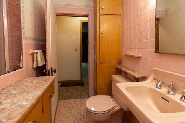 1700 Case Ave E, Saint Paul, MN 55106 - bathroom with tile walls, a sink, toilet, and tile patterned flooring