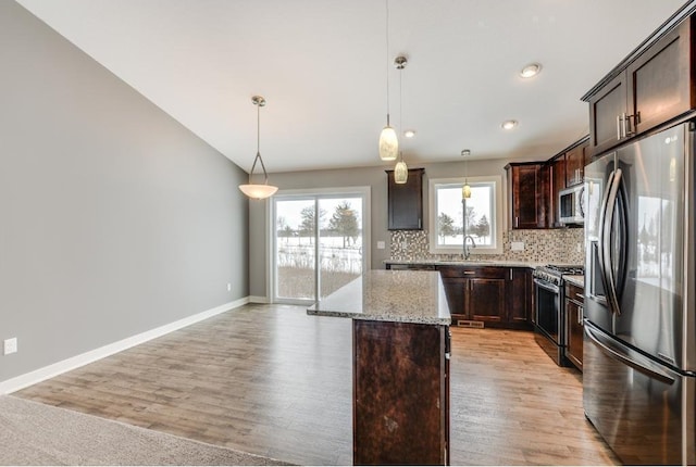 4781 261st St, Wyoming, MN 55092 - kitchen featuring stainless steel appliances, dark brown cabinetry, light wood-style flooring, tasteful backsplash, and lofted ceiling
