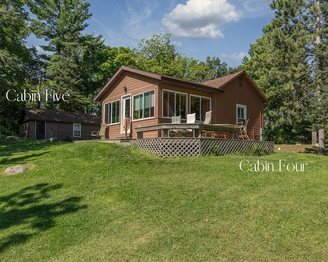 1409 Wabedo Pass Rd NE, Longville, MN 56655 - rear view of property featuring a yard, a wooden deck, and a sunroom
