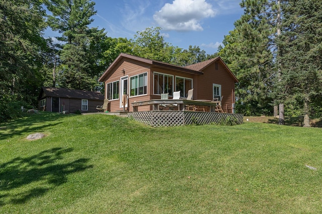 1409 Wabedo Pass Rd NE, Longville, MN 56655 - rear view of property featuring a yard, a deck, a sunroom, and an outbuilding