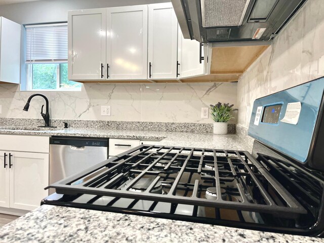 2616 30th Ave S, Minneapolis, MN 55406 - kitchen featuring stainless steel dishwasher, exhaust hood, a sink, white cabinetry, and backsplash