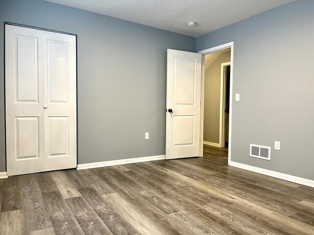 2616 30th Ave S, Minneapolis, MN 55406 - unfurnished bedroom with baseboards and dark wood-type flooring