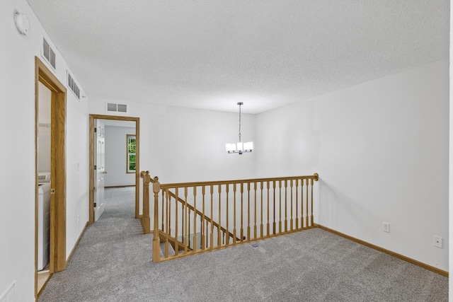 15481 Frost Path Unit 1803, Apple Valley, MN 55124 - hallway featuring carpet flooring, an upstairs landing, a chandelier, washer / clothes dryer, and a textured ceiling