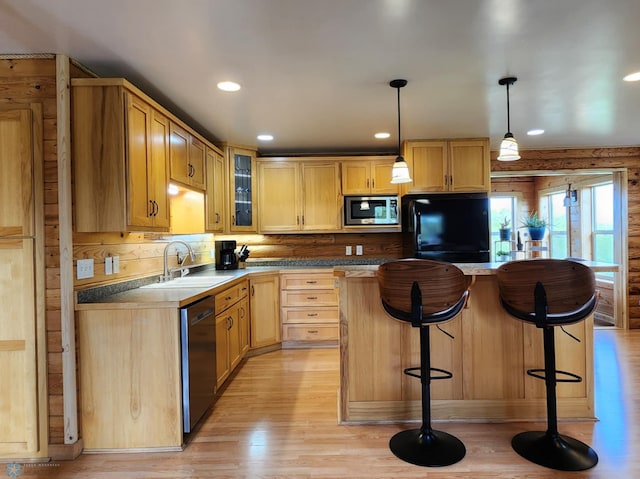 25712 15th Ave N, Highland Grove Twp, MN 56549 - kitchen with a sink, dishwashing machine, stainless steel microwave, a breakfast bar area, and glass insert cabinets